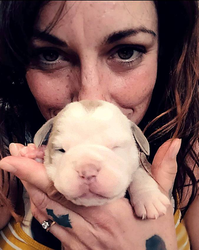 Hayley holding a newborn bulldogge puppy